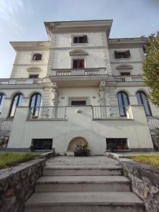 een groot wit gebouw met een trap ervoor bij Villa Santoni Guest House in Orte