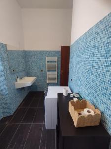 een blauw betegelde badkamer met een wastafel en een bad bij Villa Santoni Guest House in Orte