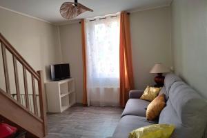 a living room with a couch and a window at Escapade à Éguzon Maison 3 chambres in Éguzon-Chantôme