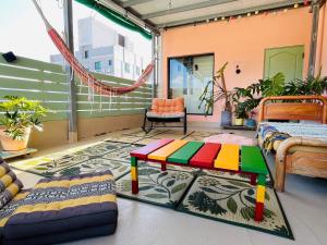 a room with a bed and a table on a balcony at 4 - 8人包棟 Good Trip Townhouse 菇憩民宿 加勒比海海島風 in Hengchun South Gate