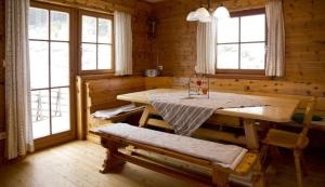 a dining room with a table in a log cabin at Kuhgrabenhütte in Klippitztorl
