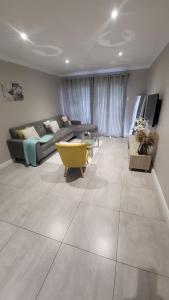 a living room with a couch and a table at The best uptown experience in the windy city in Gqeberha