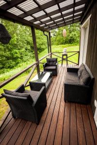 Holiday cabin 'CRANE' في Avotkalni: شرفة مع أرائك وكراسي على سطح خشبي +6 صور