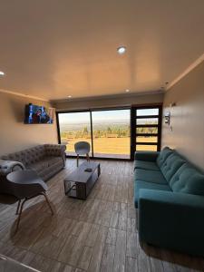 una gran sala de estar con un sofá verde y una mesa. en Cabañas Bello Atardecer, en Constitución 4 fotos más