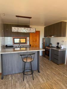 una cocina con barra y un bar con taburete en Cabañas Bello Atardecer, en Constitución