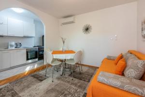 un soggiorno con un divano, un tavolo e una cucina di Apartmani Evica - App 1 a Crikvenica