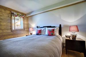 a bedroom with a large bed and two lamps at Hameaux du glaciers in Les Houches