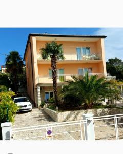un edificio con una palma di fronte di Apartmani Evica - App 1 a Crikvenica