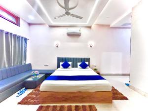 Tiger Heaven Resort في Tāla: غرفة نوم بها سرير كبير وأريكة زرقاء +28 صورة