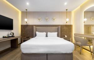 a bedroom with a large white bed and a desk at CheckInn Garki, Abuja in Abuja +36 photos