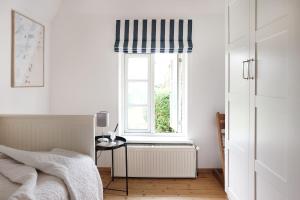 a bedroom with a bed and a window with a radiator at Kembser Cottage - Ostholstein - NEU! in Behrensdorf