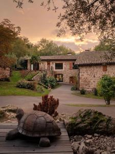 una estatua de tortuga frente a una casa de piedra en Clos du Régrillon, en Pélussin