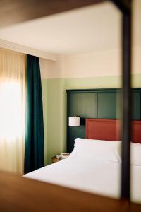 Un dormitorio con una cama grande y una ventana. en Honest Granada Hotel, en Granada