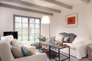 a living room with white furniture and a large window at Kembser Kate - Ostholstein - NEU! in Behrensdorf