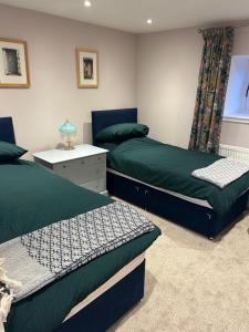 een slaapkamer met 2 bedden en een nachtkastje bij Calsie Cottage, Clatt in Kirktown of Clatt