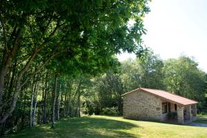 a small stone building in the middle of a field at A Maquía de Medín in O Pino 