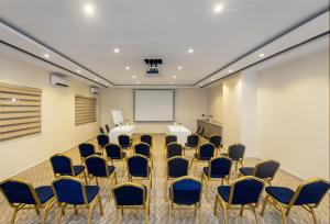 a conference room with a table and chairs and a whiteboard at CheckInn Garki, Abuja in Abuja