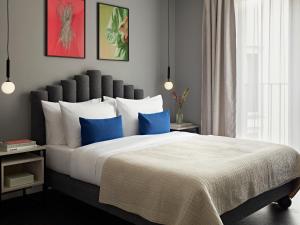 a bedroom with a large bed with blue pillows at Numa Berlin Boxer in Berlin