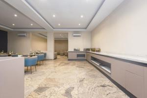 a restaurant with tables and chairs in a room at CheckInn Garki, Abuja in Abuja