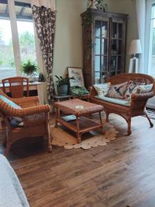 a living room with wicker chairs and a table at Le jardin de Christine in Vinneuf