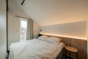 a bedroom with a white bed and a window at APT Nadmorskie - GreenPort z basenem i strefą SPA in Kołobrzeg +19 photos