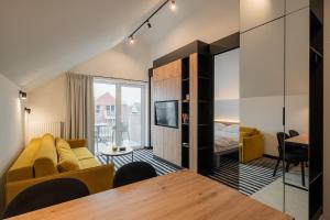 a living room with a couch and a table at APT Nadmorskie - GreenPort z basenem i strefą SPA in Kołobrzeg