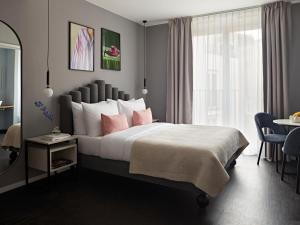 a bedroom with a large bed with pink pillows at Numa Berlin Boxer in Berlin
