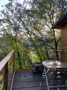 a wooden deck with a table and a grill at Cabane & Dîner Gourmet Inclus in Barjols