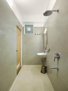 a bathroom with a sink and a mirror at Gopuram Grand in Madurai