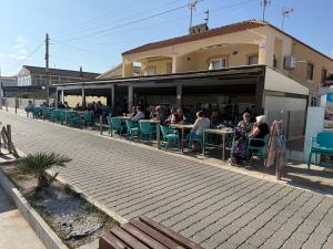 un grupo de personas sentadas en mesas fuera de un edificio en Royal Beach House Vista Mar, en La Mata