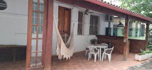 a patio with a hammock and a table and chairs at Casa de Lorna 2 in Rio de Janeiro