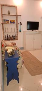 a living room with a blue table and a tv at Casa de Lorna 2 in Rio de Janeiro