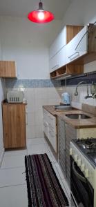 a kitchen with white cabinets and a red light at Casa de Lorna 2 in Rio de Janeiro +10 photos