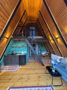 an attic kitchen and living room with a wooden ceiling at Cottage Sataplia in Kutaisi