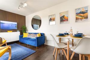 a living room with a table and a blue couch at Rigg & Rest Apartment - Bowness in Bowness-on-Windermere