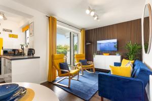 a living room with yellow chairs and a kitchen at Rigg & Rest Apartment - Bowness in Bowness-on-Windermere +13 photos