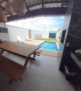 Un comedor con mesa y una piscina. en Casa de férias Mirante Casa mar, en Prado 12 fotos más