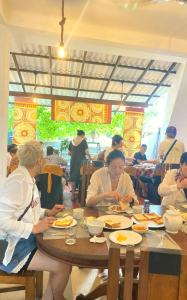 Un grupo de personas sentadas en una mesa comiendo comida en Sea wind, en Mirissa