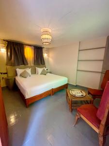 een slaapkamer met een groot bed en een stoel bij Riad Numidia in Marrakesh