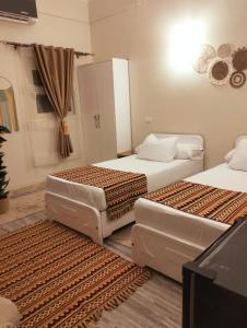 a bedroom with two beds and a window at Wonji house in Abu Simbel +28 photos