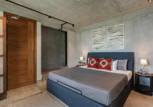 ein Schlafzimmer mit einem großen Bett mit roten Kissen in der Unterkunft LohonoStays Amani Villa 9A in Coonoor