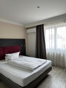 Ένα ή περισσότερα κρεβάτια σε δωμάτιο στο Astralis Hotel Domizil