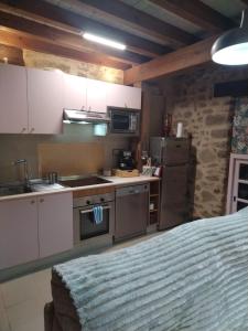 una cucina con mobili bianchi, un lavello e un frigorifero di Más Quimera a Gilgarcía