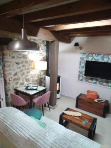 una camera da letto con un letto, un tavolo e una TV di Más Quimera a Gilgarcía