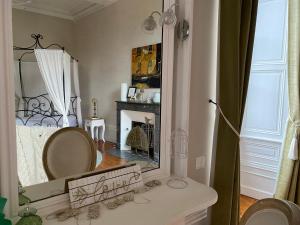 a bathroom with a mirror and a bed and a sink at Le Relais d'Angély in Saint-Jean-dʼAngély