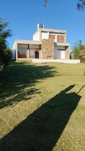 una casa con una gran sombra en el césped en CASA QUINTA CON ESPECTACULAR VISTA Al RÍO, en General Alvear