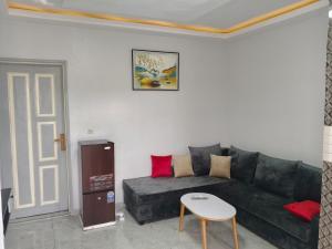 Résidence Lacasa في أبيدجان: غرفة معيشة مع أريكة سوداء وطاولة