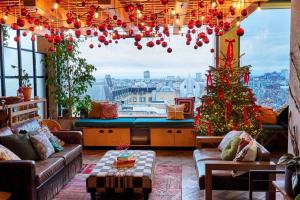a living room with a christmas tree and a large window at Treehouse Hotel London in London