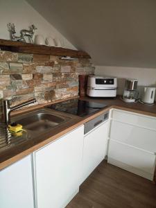 Ferienwohnung Goldfasan في لام: مطبخ مع حوض وجدار من الطوب