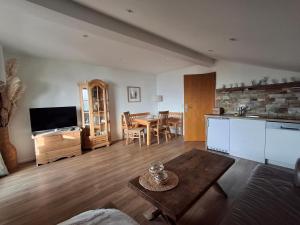 Ferienwohnung Goldfasan في لام: غرفة معيشة مع مطبخ وغرفة طعام